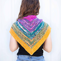 Person wearing a colorful triangular shawl on a white background