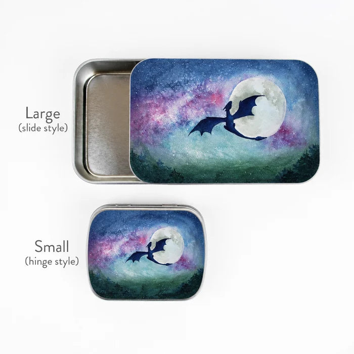 Large slide-style and small hinge-style Dragon Moon storage tins side by side with size labels, both showing watercolor dragon moon galaxy artwork on lids