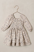 Floral dress on a hanger against a plain background