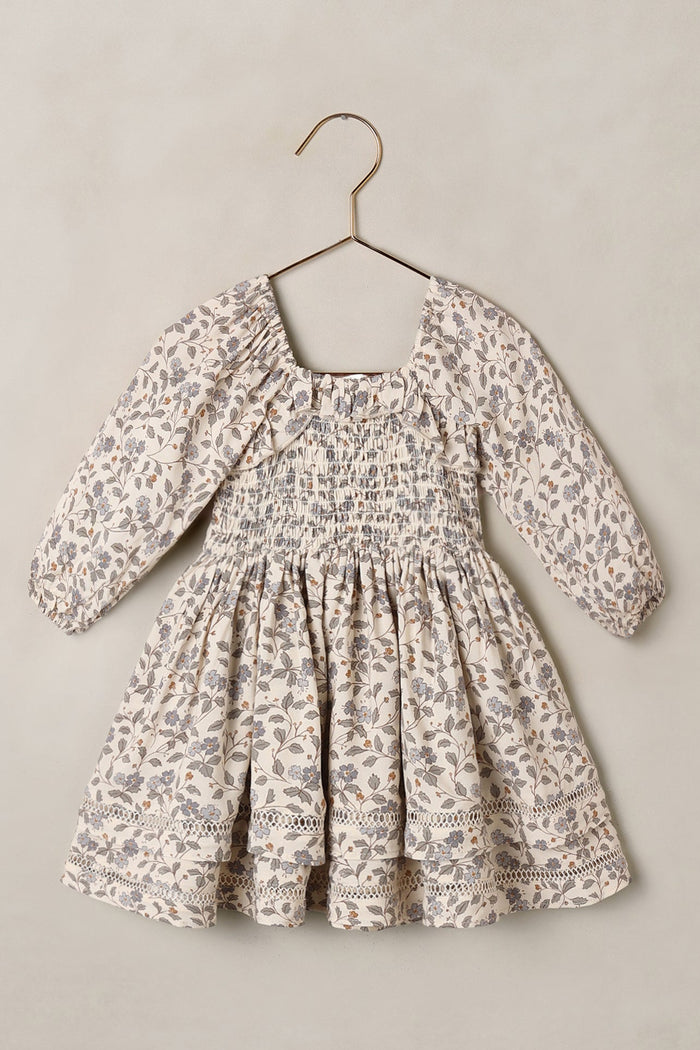 Floral dress on a hanger against a plain background