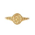 Top view of a gold oval signet ring featuring an embossed floral vine design on a white background.