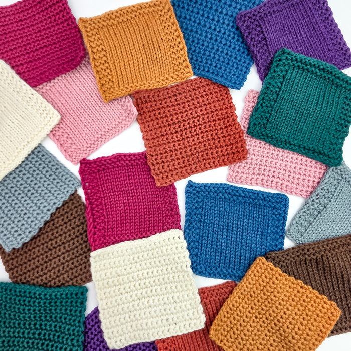 Grid of small knitted swatch samples in Everyday Merino worsted weight yarn showing the full color range including green, teal, pink, blue, brown, cream, and more