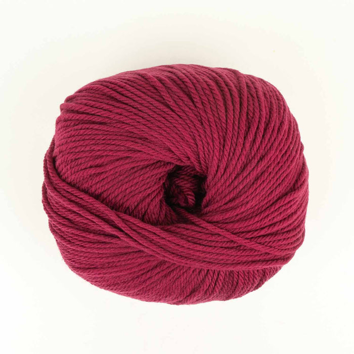 Close-up of Everyday Merino worsted weight yarn ball in Sugar Beet (deep pink) showing the smooth superwash merino fiber texture
