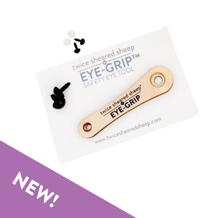 Eye Grip safety eye tool on branded retail card with safety eyes and clear washers scattered alongside the wooden tool
