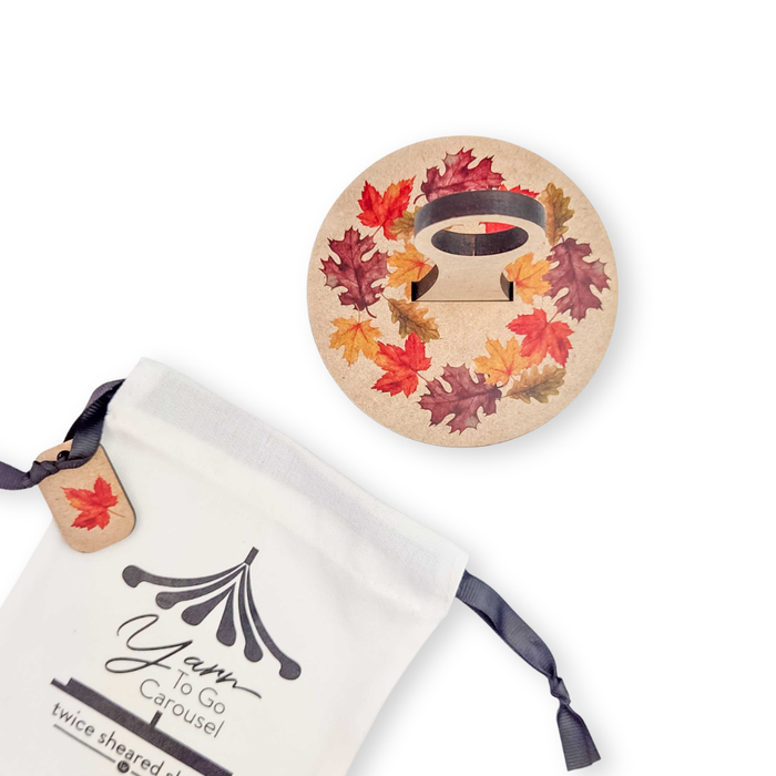 Fall Leaves Carousel lid with autumn leaf wreath shown with its cream drawstring storage bag and leaf hang tag