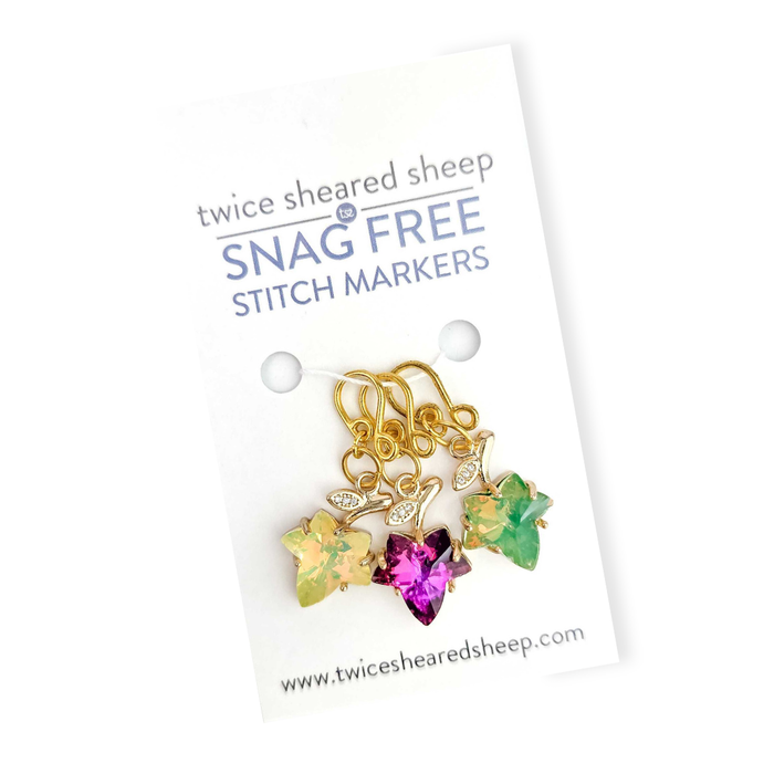 Fall Leaves Melody snag free stitch markers on a Twice Sheared Sheep card, three gold maple leaf crystal charms in yellow, magenta, and green