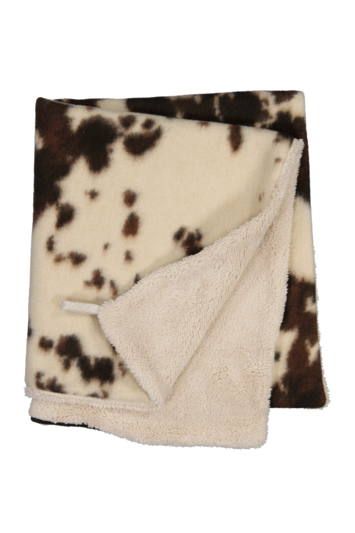 Blanket with brown and white cow print pattern on a white background