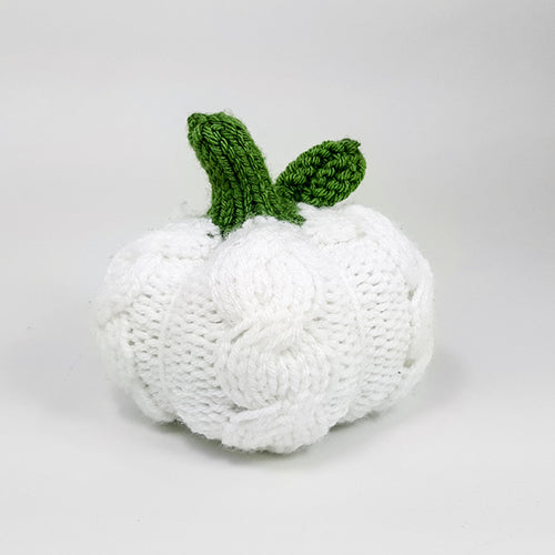 White cable-knit pumpkin shown from a slightly different angle highlighting the cable stitch texture and green knitted stem