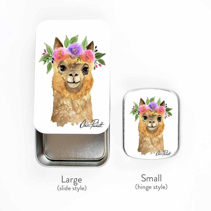 Flower Alpaca storage tin side-by-side size comparison showing the large slide style and small hinge style, both featuring the watercolor flower-crowned alpaca artwork by Dawn Prickett