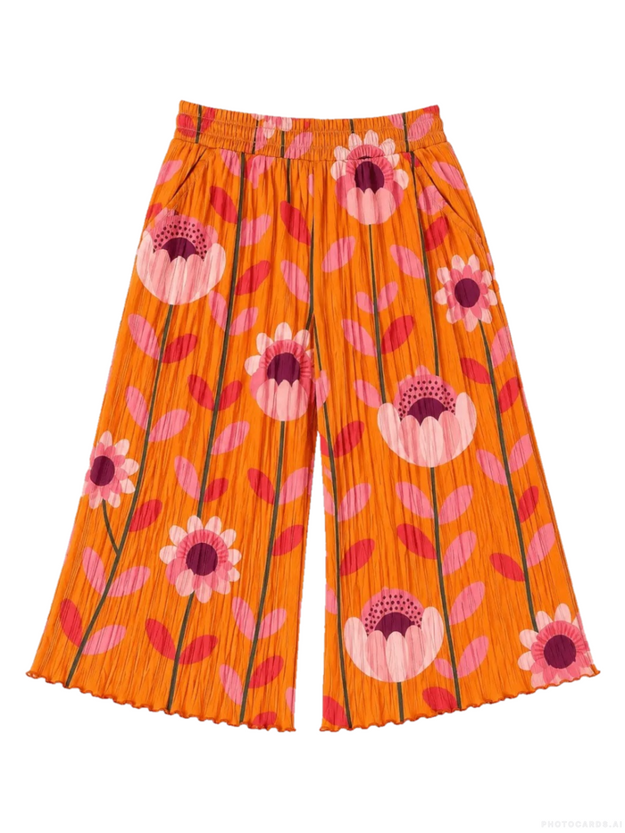 Bright orange pleated wide-leg pants featuring a retro floral and leaf pattern in pink, red, and purple, displayed flat against a white background.