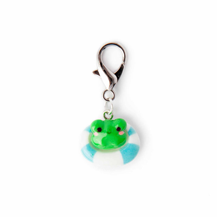 Close-up of pool float frog lobster-clasp stitch marker charm showing the green kawaii frog with pink cheeks sitting in a blue and white striped pool float ring
