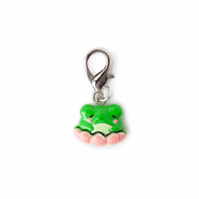Close-up of lily pad frog lobster-clasp stitch marker charm showing the sleepy green kawaii frog with pink cheeks sitting on a pink lily pad