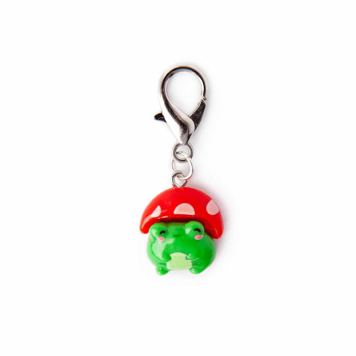 Close-up of mushroom hat frog lobster-clasp stitch marker charm showing the green kawaii frog with pink cheeks wearing a red and white polka-dot mushroom cap