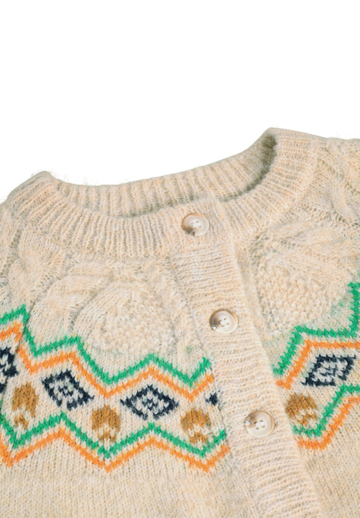 Close-up of a beige knitted sweater with geometric pattern on a white background