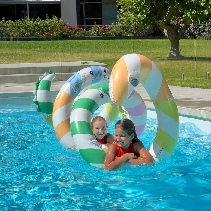 Two children in a pool with colorful inflatable giant snake.