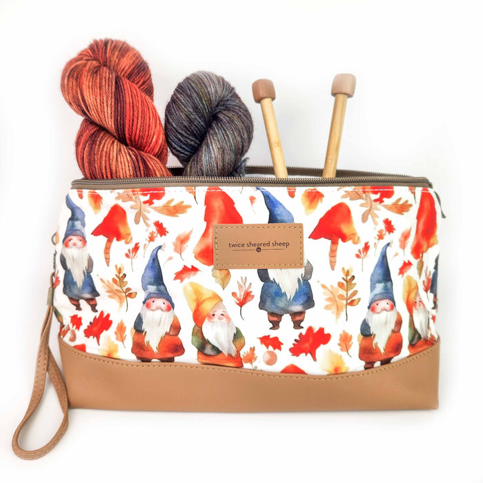 Gnome Friends Trinity Bag filled with yarn skeins and knitting needles showing autumn gnome and leaf print with leather base