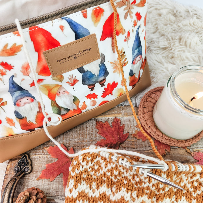 Gnome Friends Trinity Bag in autumn scene with colorwork knitting, candle on crochet coaster, and fall leaves