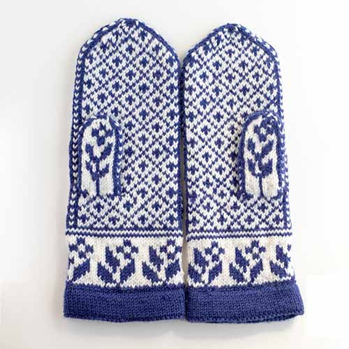 Back side of the Gnomes in Love mittens laid flat showing the navy and white stranded colorwork gnome pattern with dotted background