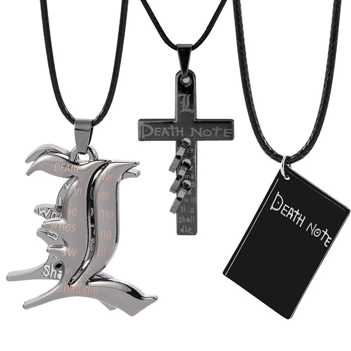 Three matte black pendants including a stylized 'L' emblem, a cross with spiral details, and a notebook charm, all suspended from minimalist black cords on a white background.