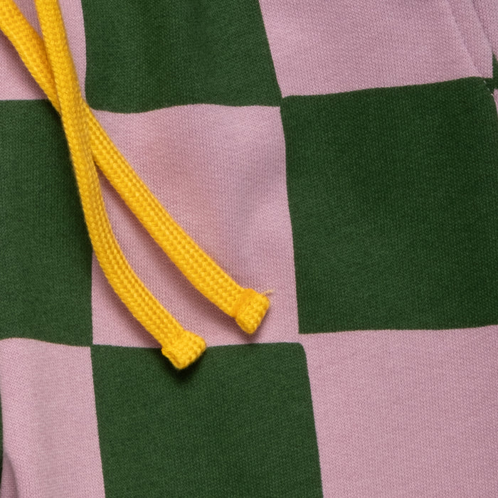 Close-up of a checkered fabric with green and pink squares and yellow drawstring.