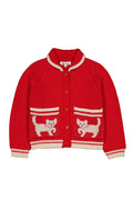 A red knit cardigan sweater with cream-colored trim, featuring two front pockets decorated with knitted white and red cat motifs, shown against a plain white background.
