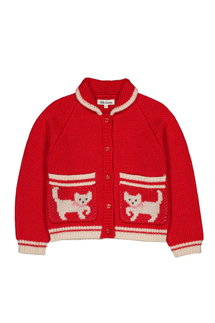 A red knit cardigan sweater with cream-colored trim, featuring two front pockets decorated with knitted white and red cat motifs, shown against a plain white background.
