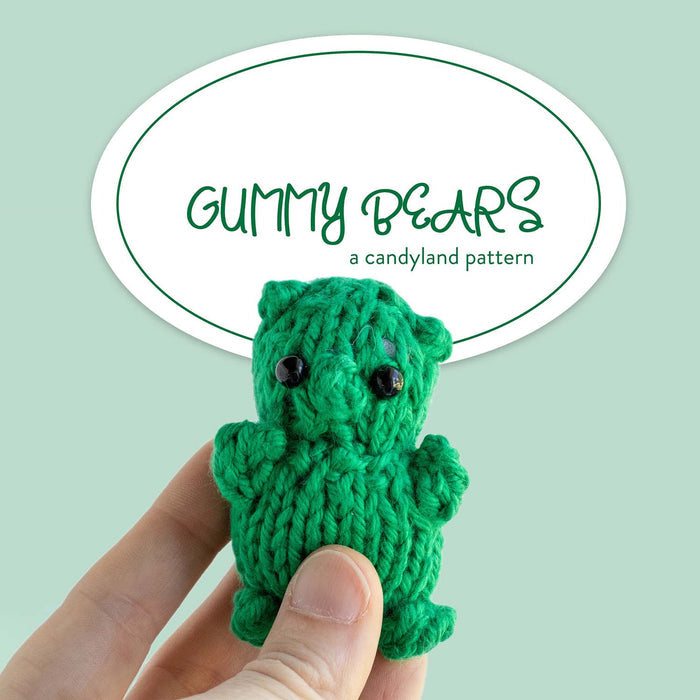 Gummy Bears knitting pattern cover on sage green background showing hand holding a green knitted gummy bear stuffie with safety eyes