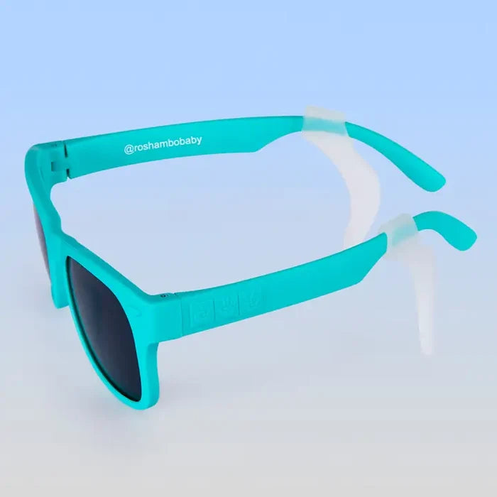 Turquoise sunglasses with a clear ear adjusters on a light blue background