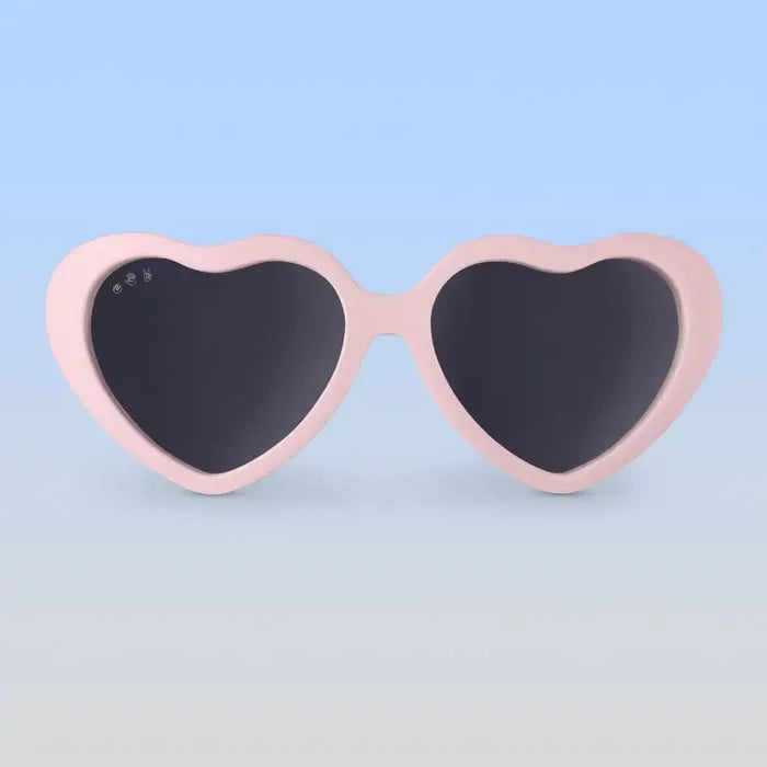 Heart-shaped sunglasses with pink frame on a light blue background