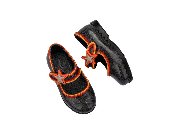 Black shoes with orange accents and star designs on a white background