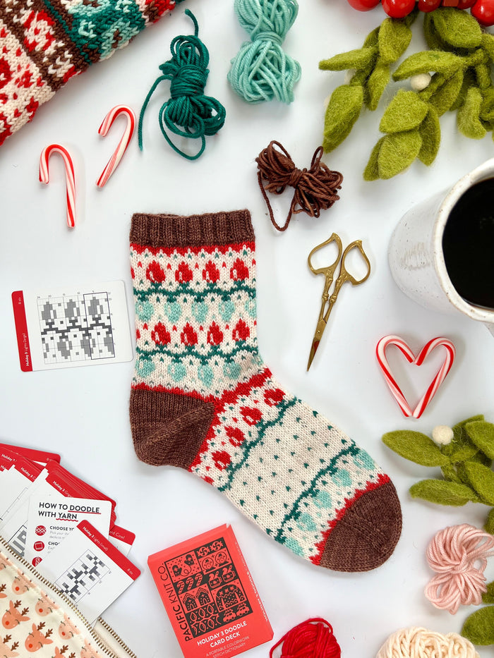Holiday 3 Doodle colorwork socks in red, green and cream with the deck and chart cards