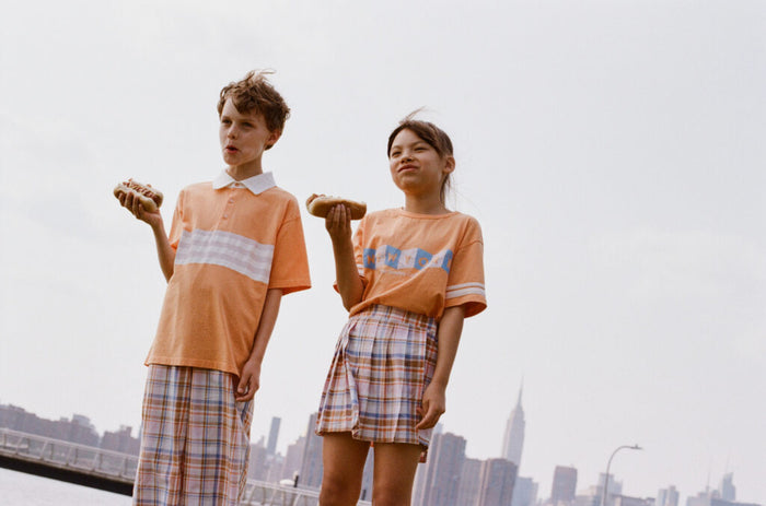 Two people wearing matching outfits with a city skyline in the background