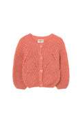 Pink knitted cardigan on a white gray background