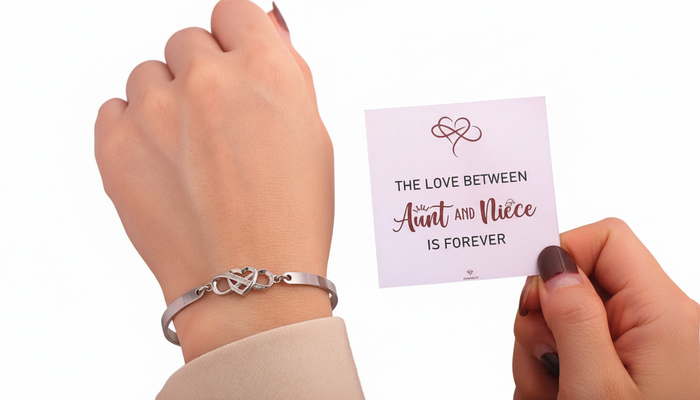 Silver infinity heart bracelet on a wrist next to a gift card that reads "The Love Between Aunt and Niece is Forever.