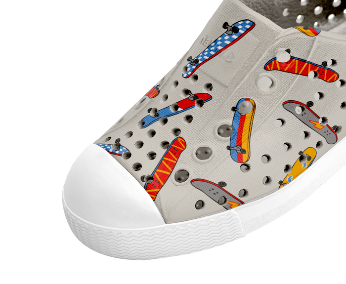 White sneaker with colorful skateboard designs on a white background