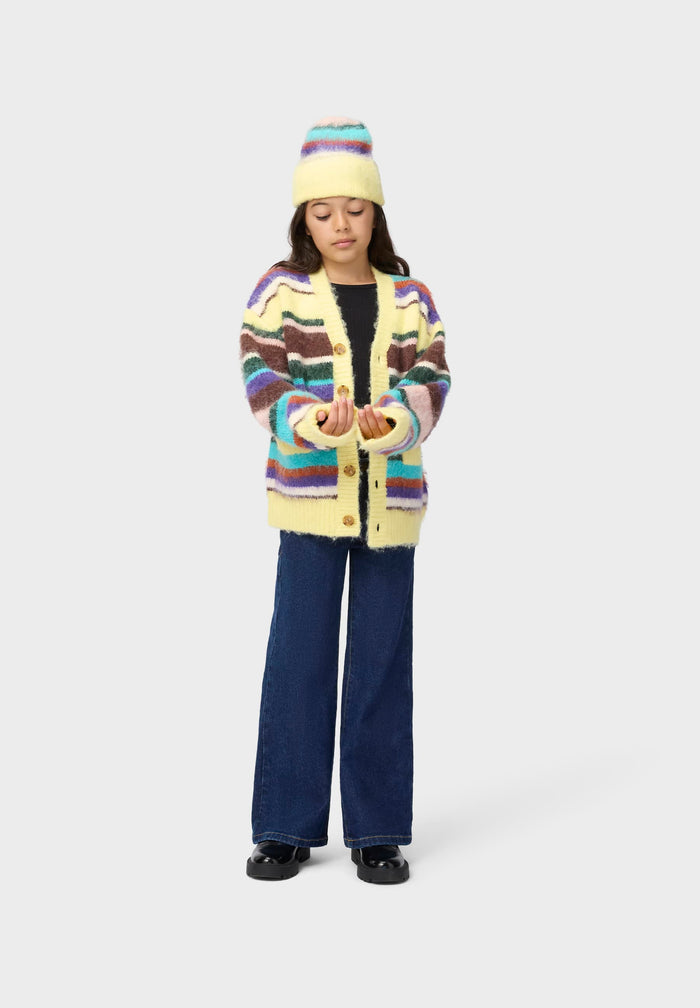 Person wearing a colorful striped sweater and hat on a white background