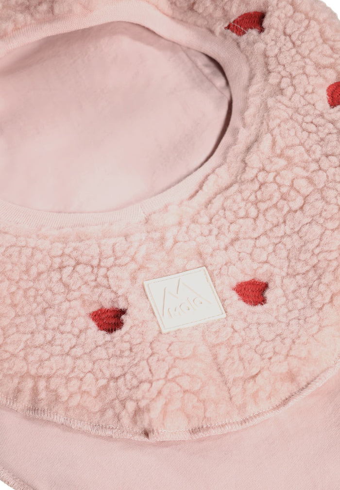 Pink textured product with red accents and a visible brand logo.