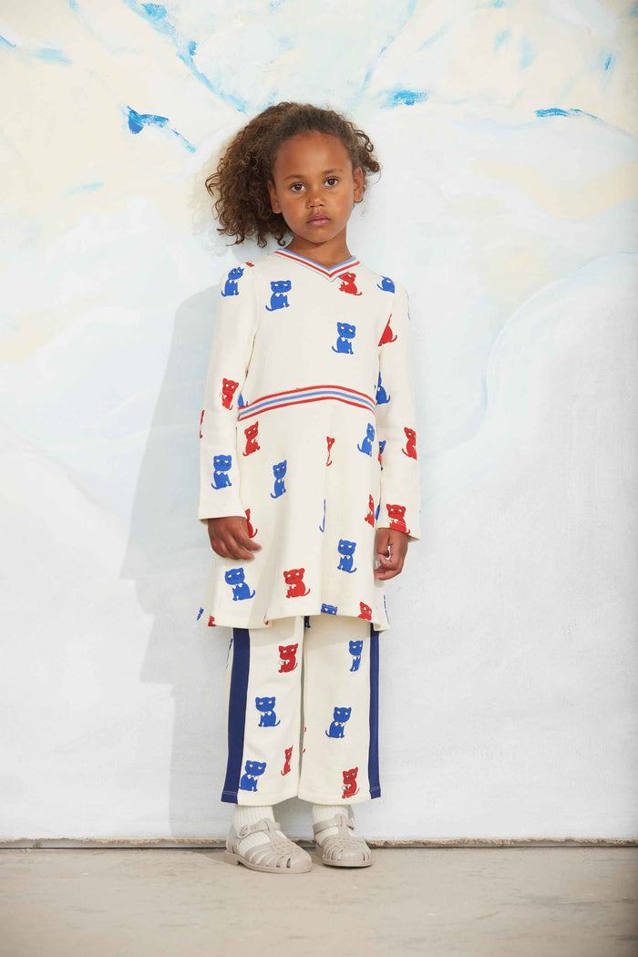 Child wearing a white outfit with red and blue patterns against a white background