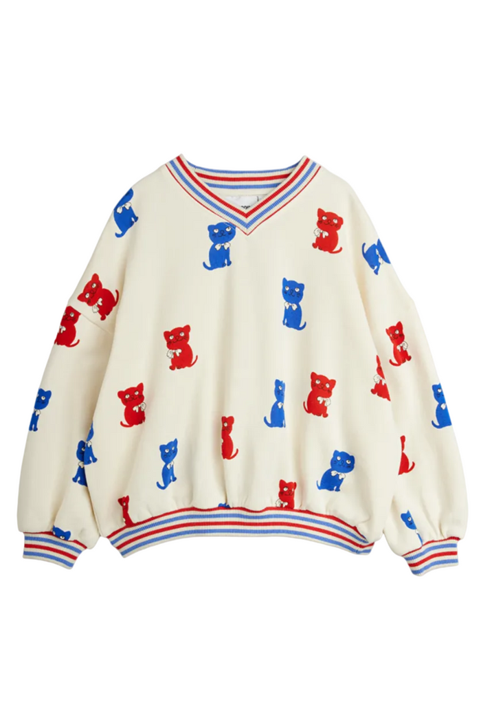 White sweater with red and blue kitten pattern on a white background
