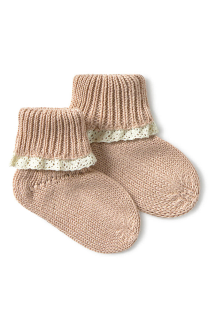 Pair of beige knitted baby socks with lace trim on a white background