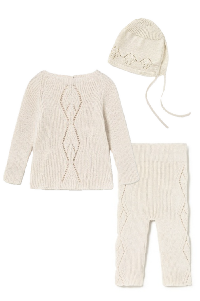 Cream-colored knit baby set with sweater, pants, and bonnet on a white background