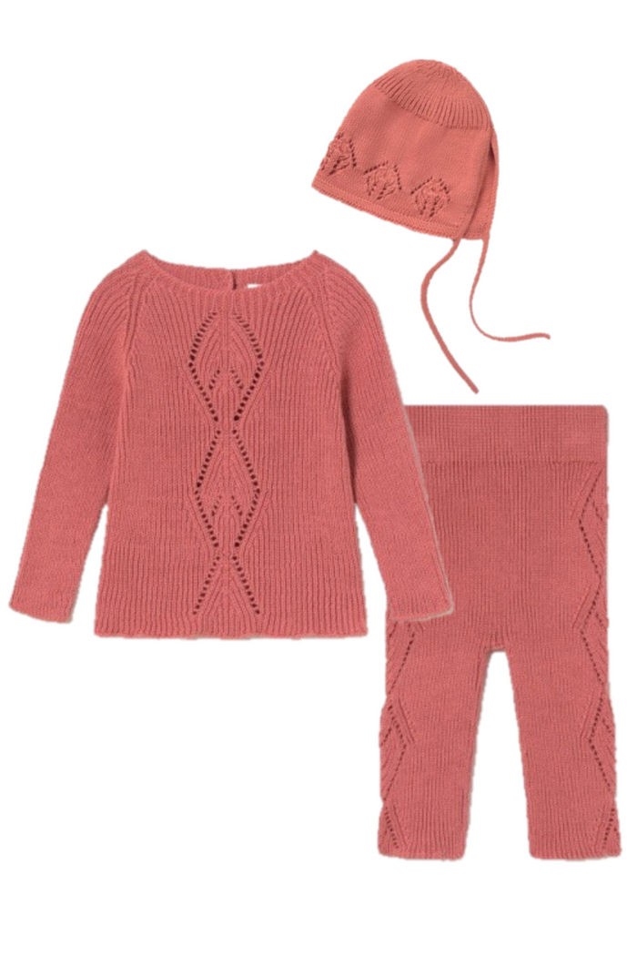Pink knitted outfit with top, pants, and hat on a white background