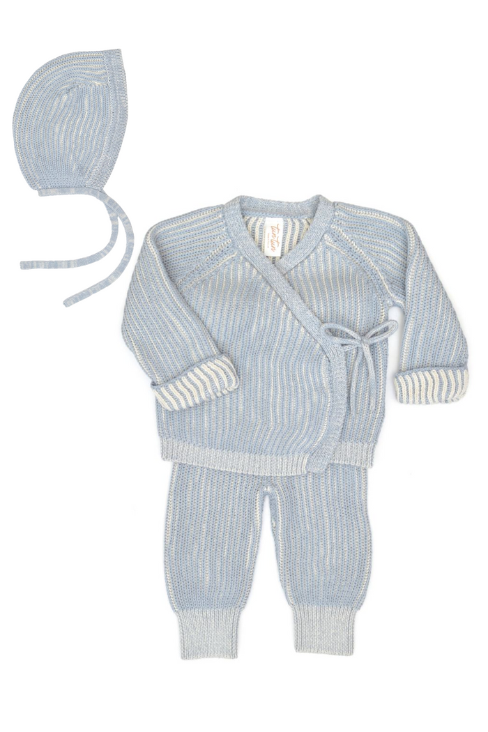 Baby outfit with knitted cardigan, pants, and hat on a white background
