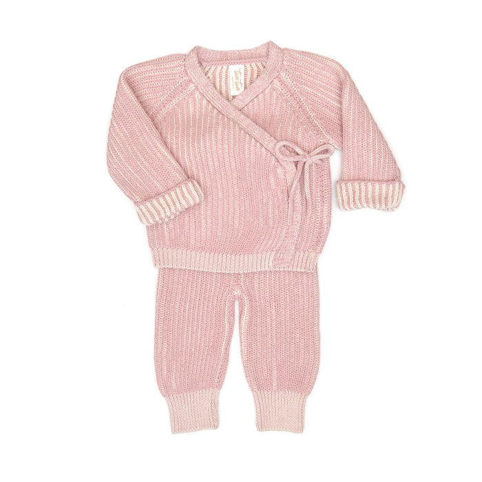 Pink knitted baby outfit on a white background