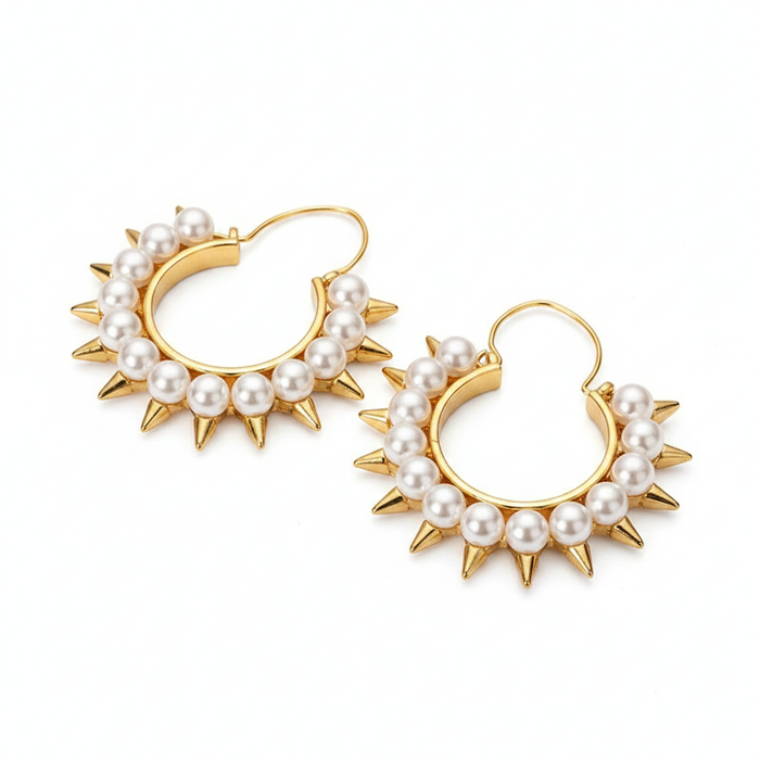 A pair of gold-toned hoop earrings featuring a row of white pearls along the outer edge, accented by sharp gold spikes between each pearl. The earrings have a classic hoop design with a wire hook closure, set against a clean white background.
