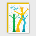 A greeting card with a bright yellow envelope, featuring three dancing tube figures in green, yellow, and blue with the text 'LET'S DANCE!' on a white card background.