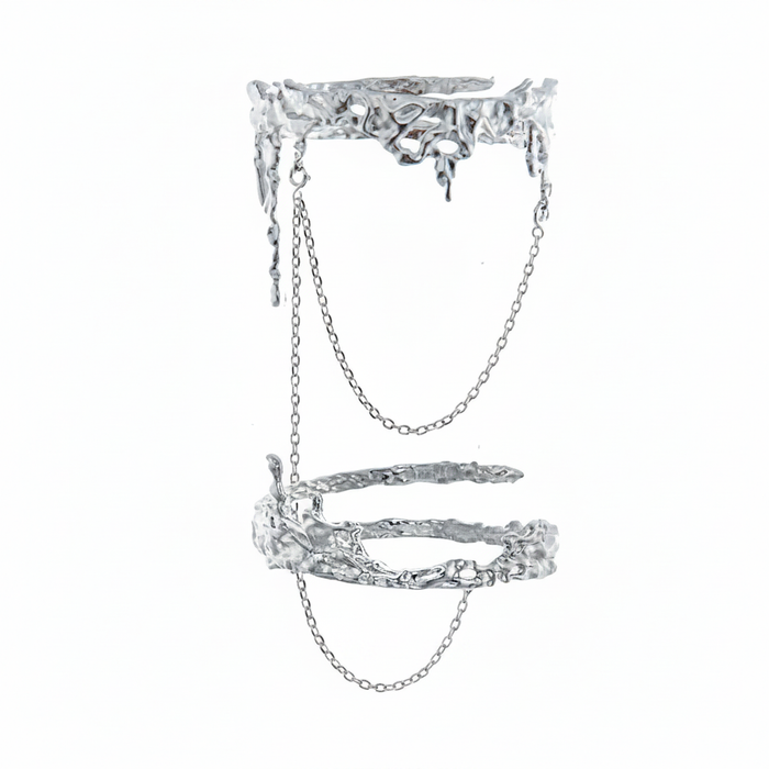 An avant-garde silver-toned double finger ring featuring a molten liquid-metal texture and delicate connecting chains, isolated on a white background.