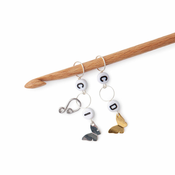 Butterfly crochet increase and decrease counter set with letter beads and silver and gold butterfly charms on wooden crochet hook