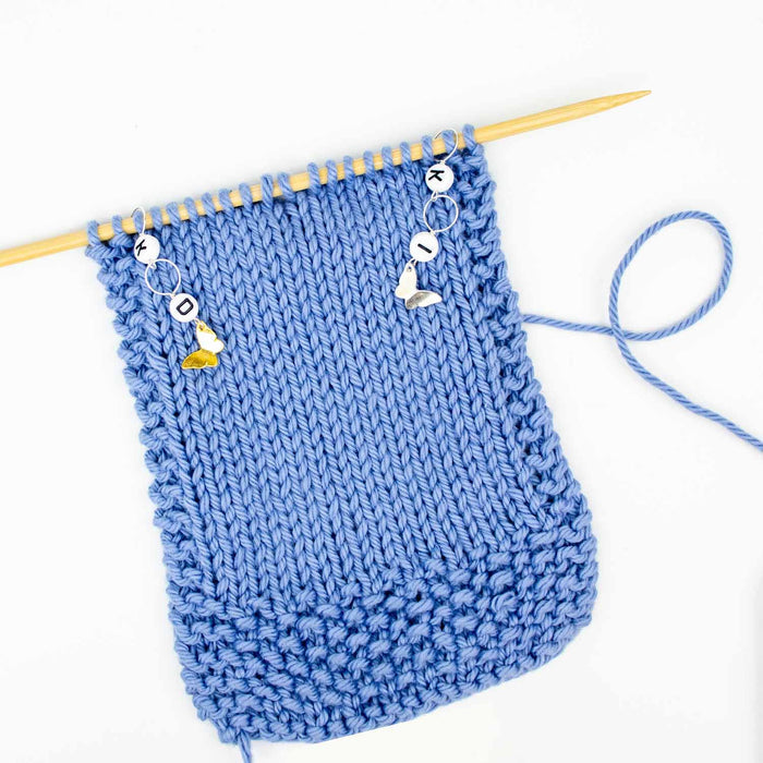 Little Butterflies increase and decrease counter chains on a bamboo knitting needle with enamel butterfly charms and letter beads I and D
