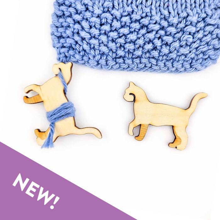 Little Cat wooden yarn bobbin in laser-cut birch wood showing the cat silhouette shape with natural wood grain, used as an end minder for knitting and crochet